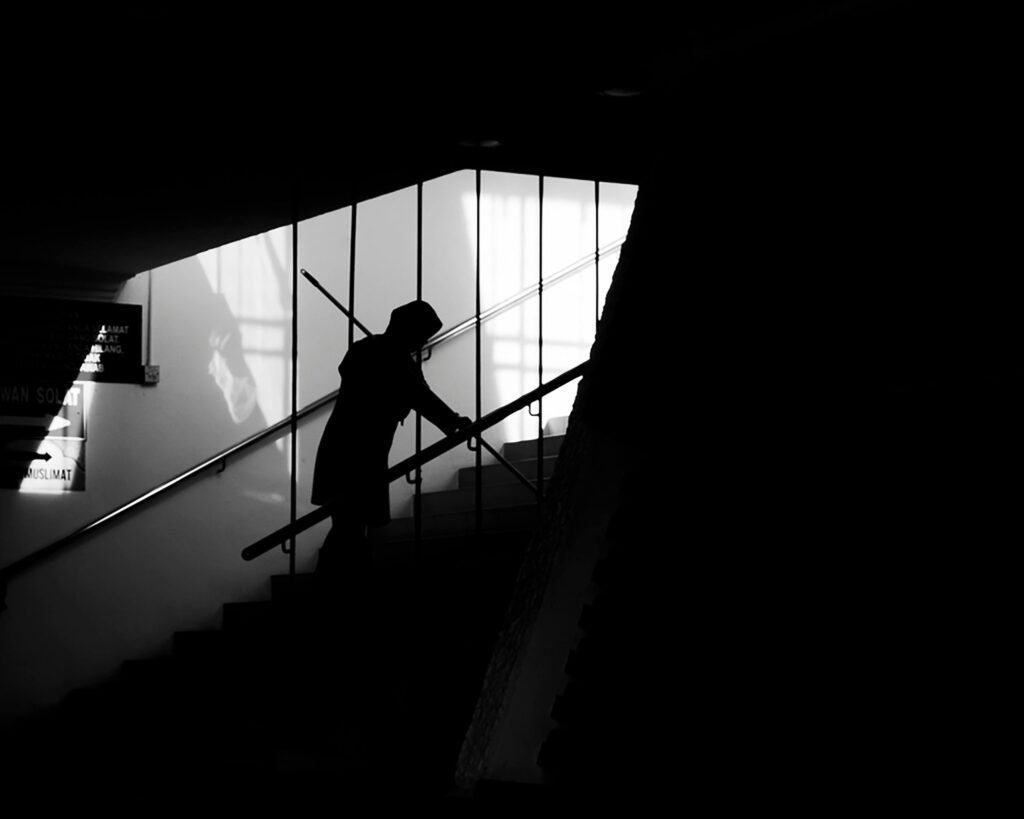 an old person going up the stairs in the dark